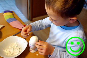 ein 4-jähriges Kind kann konzentriert ein Ei schälen